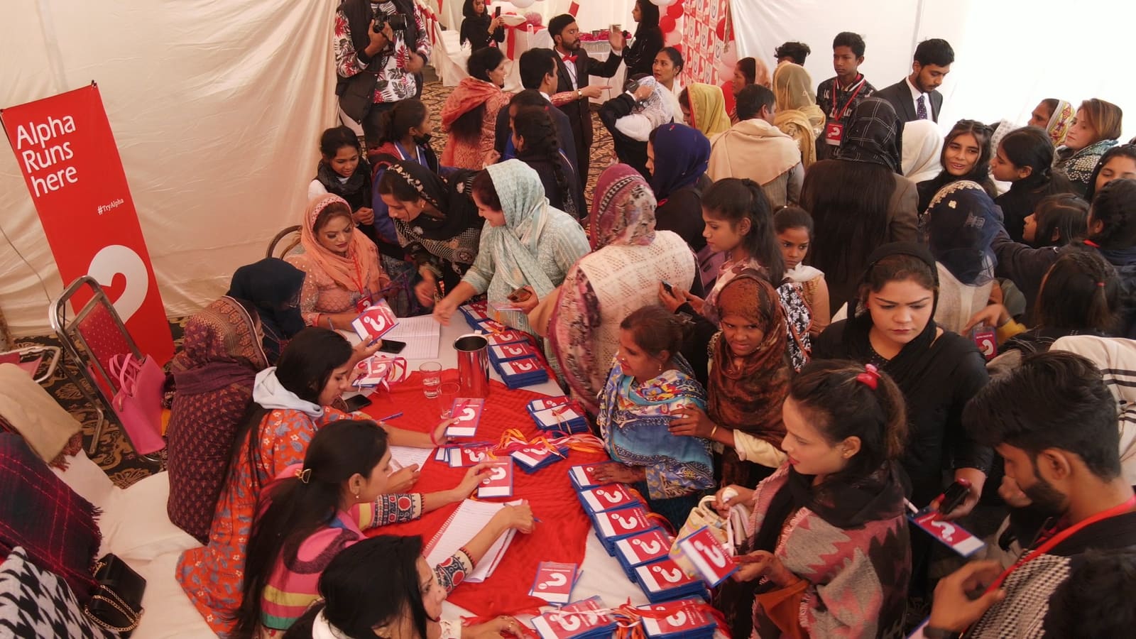 People gathering around tables at an Alpha Pakistan event