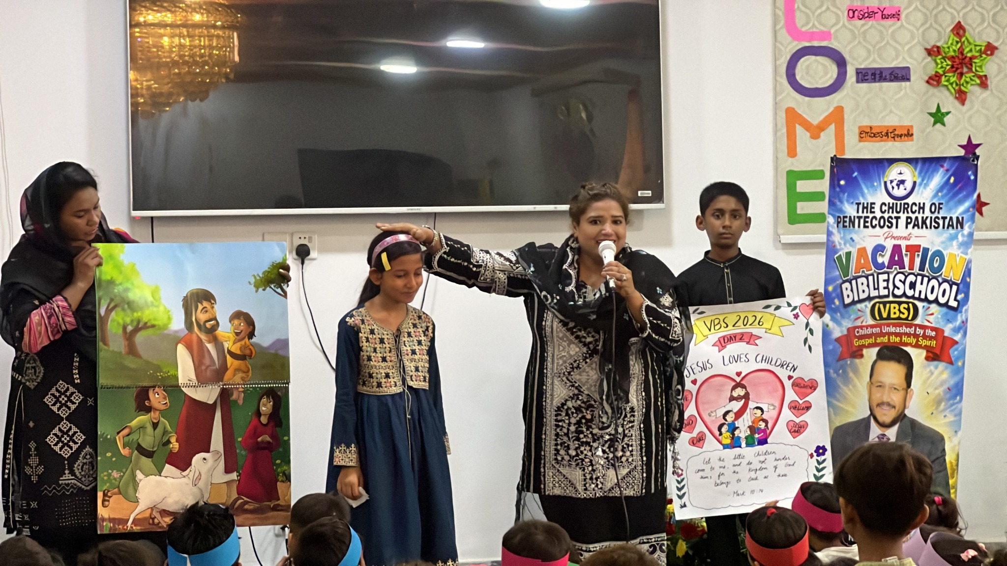 A facilitator explains Jesus’ love for children with illustrated teaching materials.
