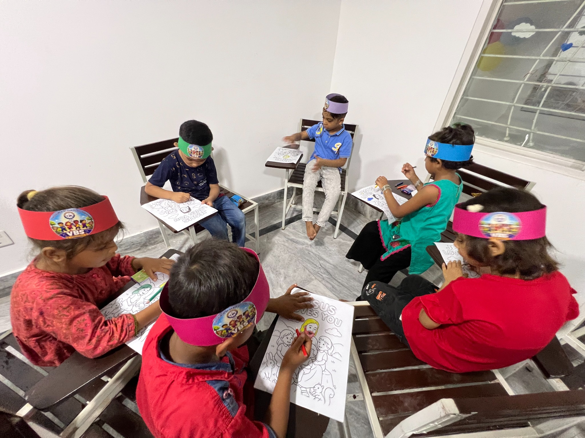 Younger children colour Bible-themed pages in a small group.