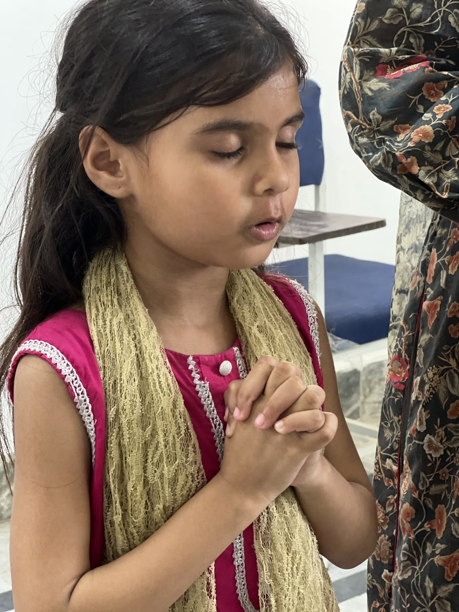 A child pauses for prayer during the programme.