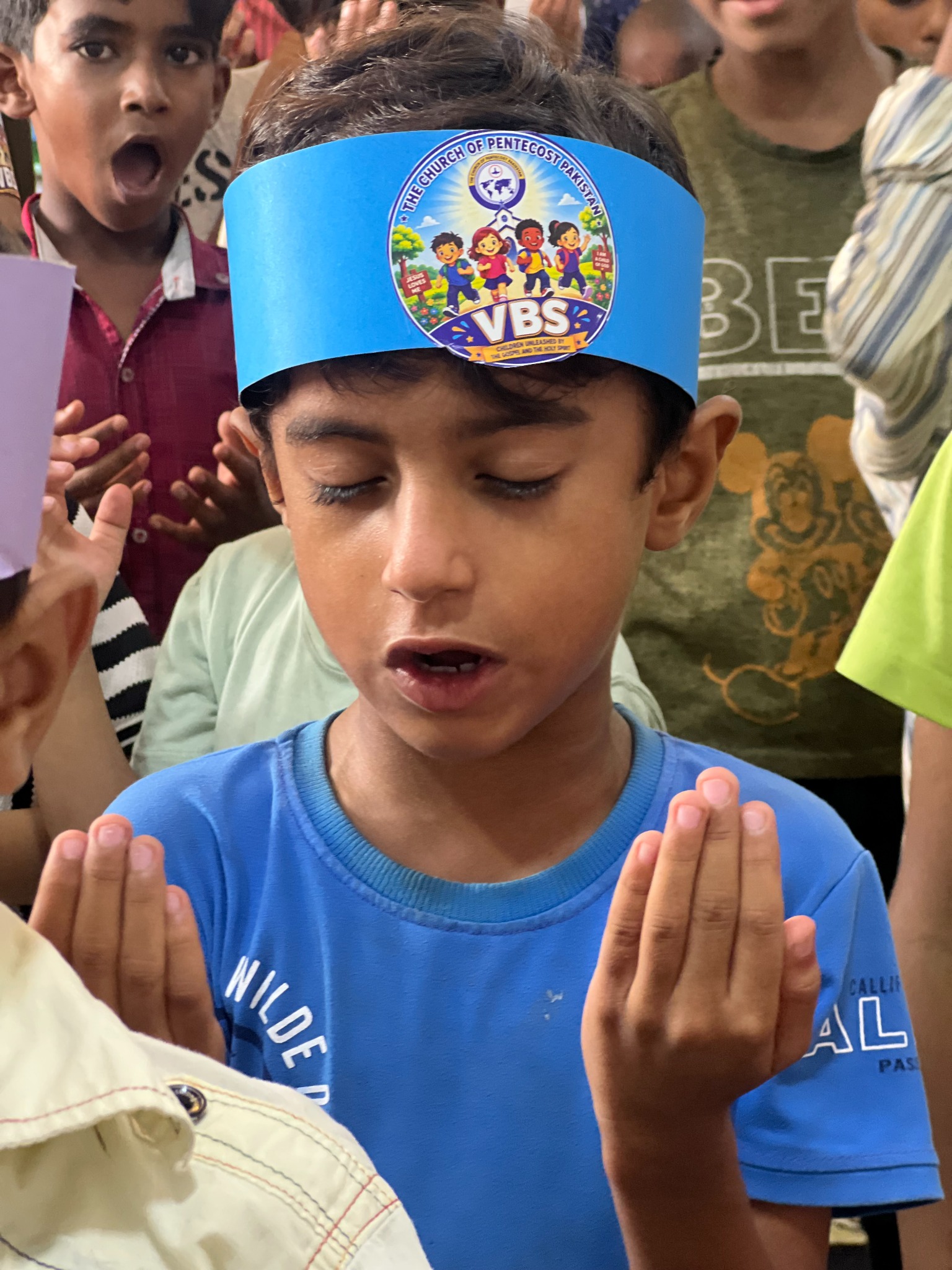 A young participant joins others in prayer.