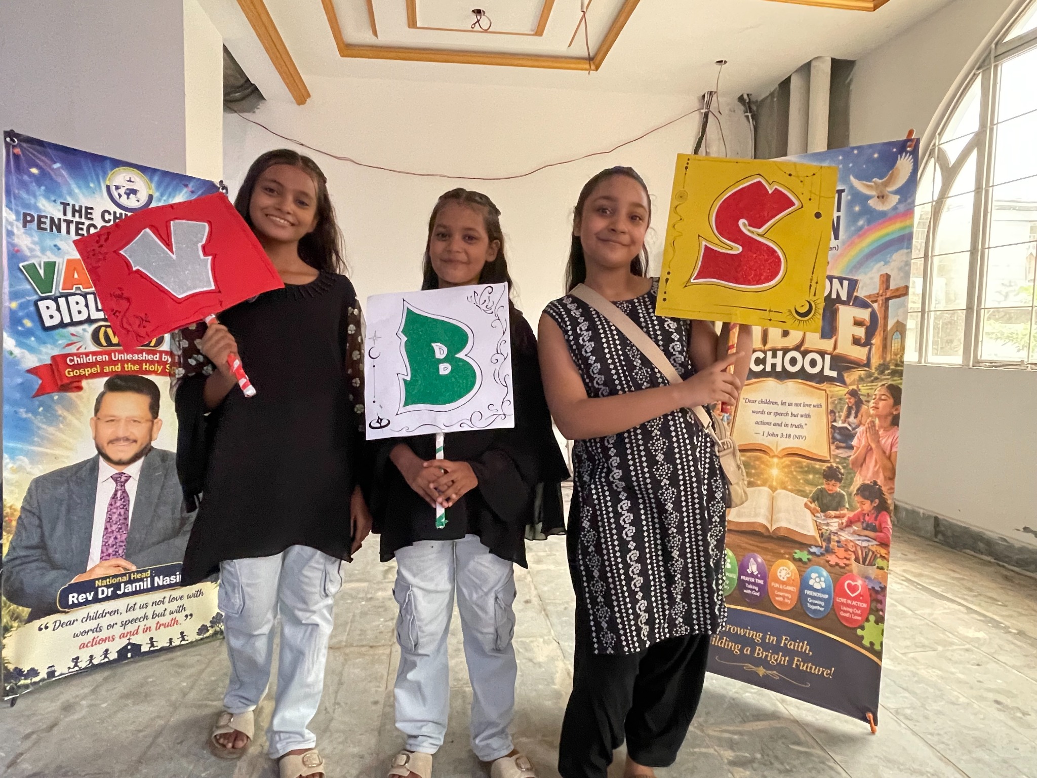 Children celebrate their shared experience with handmade VBS signs.